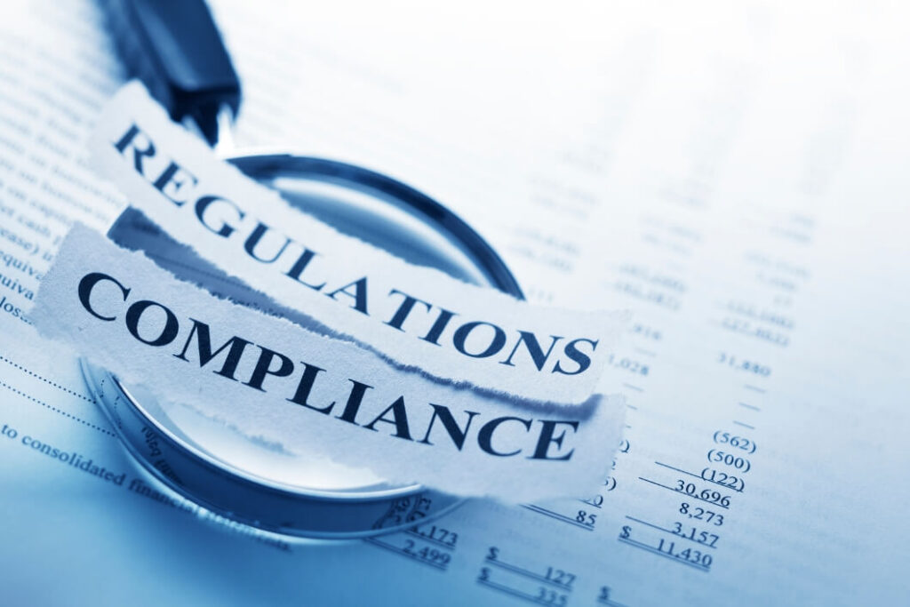 Compliance paperwork with torn 'Regulations' label under a magnifying glass, signaling regulatory scrutiny.