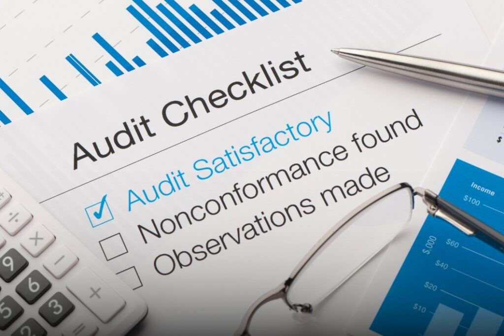 Financial audit checklist with calculator and pen